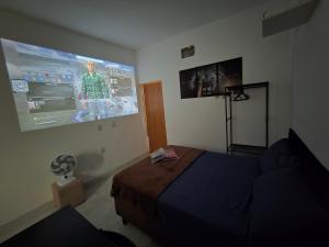 アパレシダ・デ・ゴイアニアにあるFlat completo a 24 minutos do Flamboyant Shoppingのベッドルーム1室(ベッド1台、プロジェクションスクリーン付)