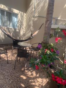 a hammock in a patio with chairs and flowers at Casa de alto padrão, 2 minutos do shopping in Tangara da Serra +8 photos