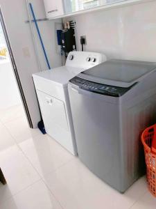 a kitchen with a washing machine and a counter at Casa Blanca #1 Beautiful modern beach house in Sámara