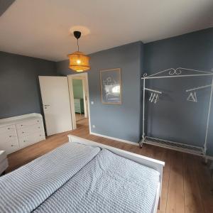 a bedroom with a bed and a blue wall at Kutscherhaus mit 2 Schlafzimmer im Zentrum von Senftenberg in Senftenberg