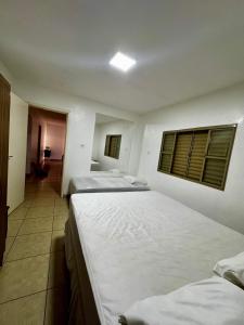 a bedroom with two beds and a room with a window at Casa Aconchego Itaici in Caldas Novas