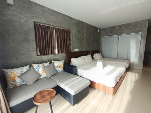 a bedroom with two beds and a couch at Makan Resort in Kanchanaburi