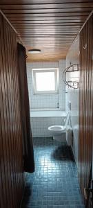 a bathroom with a toilet and a tub and a window at 2-Zimmer Wohnung mit Küche und Terrasse in Geislingen an der Steige