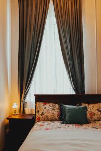 a bedroom with a bed and a window with curtains at Bērzgala Viesu Nams 