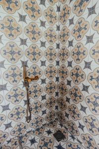 a tiled wall in a bathroom with blue and white tiles at Bērzgala Viesu Nams 