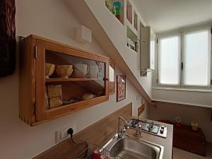 a kitchen with a sink and a wooden cabinet at La Mansarda delle Mongolfiere in Turin