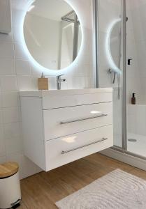 a white bathroom with a sink and a mirror at Rooms 34 in Schweinfurt