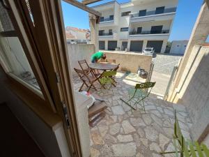 a man sitting at a table on a patio at Volme Apartment in Razvala
