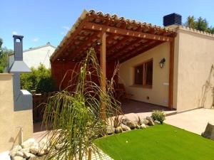 a backyard with a pergola and green grass at Apartament rural amb piscina i jardí in San Martín Sarroca