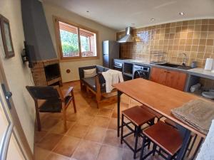 a kitchen and living room with a table and chairs at Apartament rural amb piscina i jardí in San Martín Sarroca