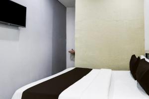 Cama en habitación con TV en la pared en Hotel O Tara Grand luxury Rooms, en Warangal 22 fotos más