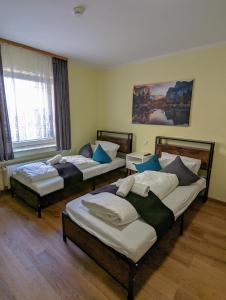 a room with three beds and a window at City Rooms Rastatt in Rastatt