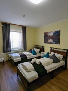 a room with four beds and a window at City Rooms Rastatt in Rastatt