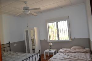 una camera da letto con due letti e un ventilatore a soffitto di Mas Solana a Huércal-Overa