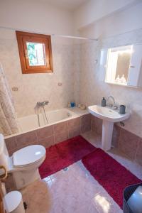 a bathroom with a tub and a toilet and a sink at Kallisti's house in Mákri +8 photos