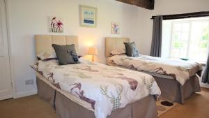 une chambre avec deux lits et une fenêtre dans l'établissement The Old Farmhouse, Yealand Redmayne, near Carnforth, à Beetham