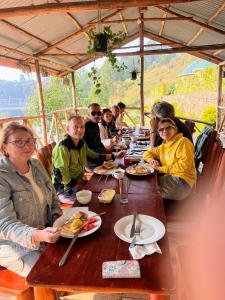 a group of people sitting at a table eating food at Antique cottages in Kabale