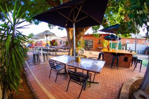 a patio with a table and chairs with an umbrella at The Piccadilly Hotel in Kalgoorlie
