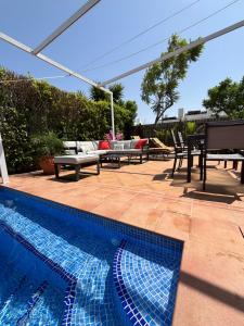 a swimming pool with a patio with a table and chairs at villa casa Aymlo in Torre-Pacheco
