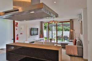 eine Küche und ein Wohnzimmer mit Herd in der Unterkunft Refúgio da Ribeira in São Vicente