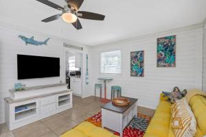 Una sala de estar con un sofá y un televisor de pantalla plana. en Teal Tropical Villa, en Largo