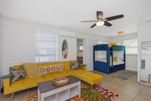 Una sala de estar con un sofá amarillo y una mesa. en Teal Tropical Villa, en Largo