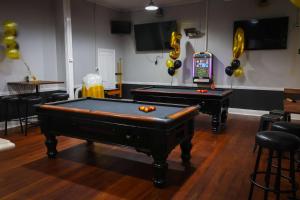 two pool tables in a room with balloons and a slot machine at The Piccadilly Hotel in Kalgoorlie