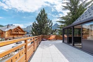 a house with a balcony with a view of the mountains at Le Cocon de Camille in Les Deux Alpes