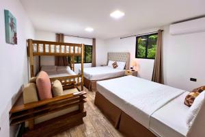 a bedroom with two beds and a bunk bed at Hotel Termales La Montaña in Ahuachapán +88 photos
