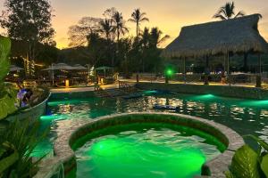 a pool at a resort with green illumination at Hotel Termales La Montaña in Ahuachapán