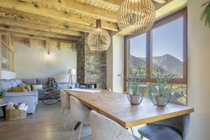a living room with a wooden table and a large window at Eth Estel de Salardú--Casa con vistas de ensueño-Fibra Optica,5TV in Salardú