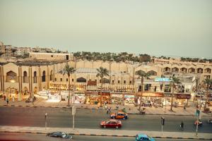 a city street with cars parked in front of a building at Town Hotel- Hurghada in Hurghada