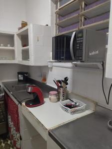a kitchen with a sink and a microwave at Oxen Hostel in Recife