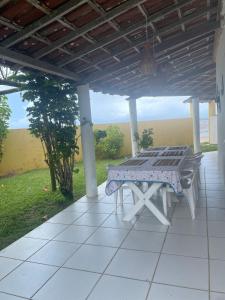 a picnic table on the porch of a house at Brisa do Mar Cumuru - Pé na Areia in Prado