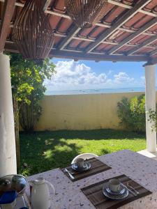 a table with a view of the ocean from a patio at Brisa do Mar Cumuru - Pé na Areia in Prado +9 photos