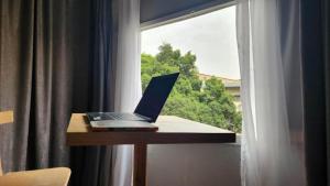 a laptop sitting on a table next to a window at AL DOKI COMFORT ROOM - Males only in Cairo