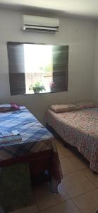 a hotel room with two beds and a window at Sol guest house in Pipa +1 photo
