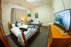 une chambre avec un lit et une télévision à écran plat dans l'établissement The Piccadilly Hotel, à Kalgoorlie