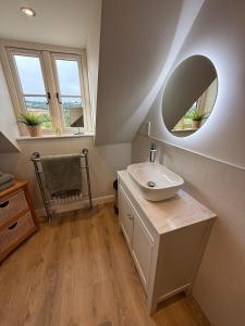 a bathroom with a sink and a mirror at Minafon Loft in Meifod