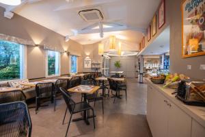 a dining room with tables and chairs in a restaurant at KYRIAD BORDEAUX SUD - Villenave d'Ornon in Villenave-dʼOrnon