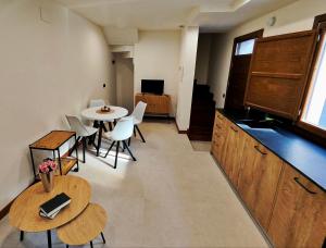 a room with a table and chairs and a kitchen at Vivienda Unifamiliar Ventana a la Clerecía in Salamanca