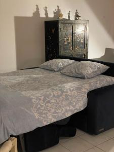 a bed with a blue comforter and two pillows at Prince de Galles in Cannes +12 photos