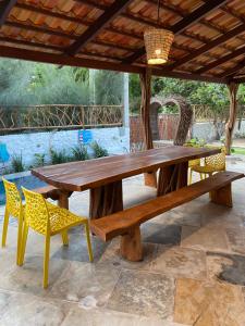 a wooden picnic table and chairs under a pavilion at Casa Nossa Preá in Prea