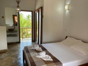 a bedroom with a bed with towels on it at Casa Nossa Preá in Prea