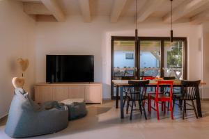 a living room with a television and a table with chairs at BINDT chalets in Hnilčík
