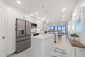 a large kitchen with white cabinets and a refrigerator at Riverside Club A209 in Marco Island