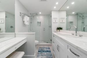 a white bathroom with a sink and a shower at Riverside Club A209 in Marco Island