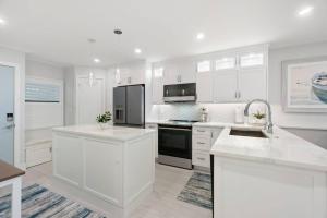a kitchen with white cabinets and a black refrigerator at Riverside Club A209 in Marco Island