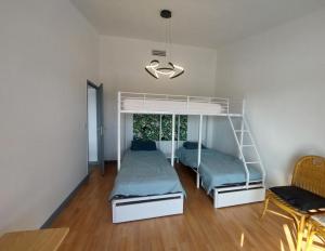 a bedroom with two bunk beds and a table at Gite du Château le Mas in Saint-Laurent-des-Hommes