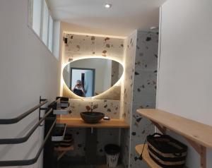 a woman taking a picture of a mirror in a bathroom at Gite du Château le Mas in Saint-Laurent-des-Hommes